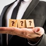 Three wooden cubes displaying question marks
