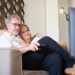 estate planning consideration, image of a middle-aged couple snuggling on a couch.