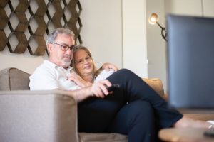 estate planning consideration, image of a middle-aged couple snuggling on a couch.