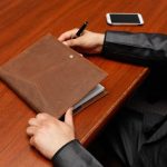 How Often Should I Update My Estate Plan. image of man's arms on a desk with pen in hand